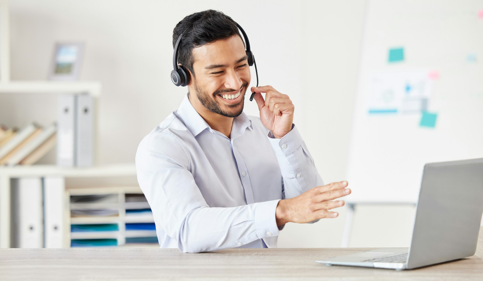 Happy businessman working in a call center. Customer service rep helping on a call. Sales agent spe